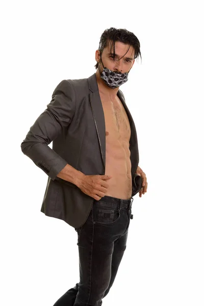 Estúdio tiro de homem bonito posando enquanto vestindo máscara e holdin — Fotografia de Stock