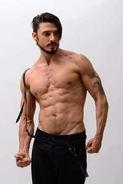 Studio shot de bel homme posant et détournant les yeux avec suspension — Photo