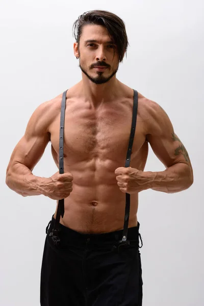 Askısız pantolon giyen yakışıklı adamın stüdyo fotoğrafı.