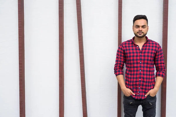 Young bearded Indian businessman relaxing at the mall in Bangkok