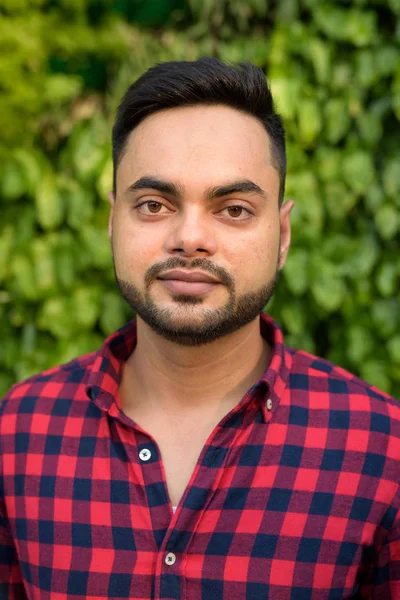 Young bearded Indian businessman relaxing at the mall in Bangkok — Stock Photo, Image