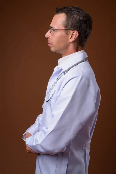 Студійний знімок лікаря чоловіка на коричневому фоні — стокове фото