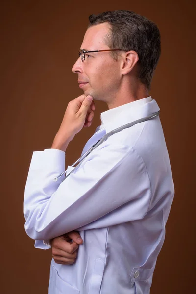 Studioaufnahme eines Arztes vor braunem Hintergrund — Stockfoto