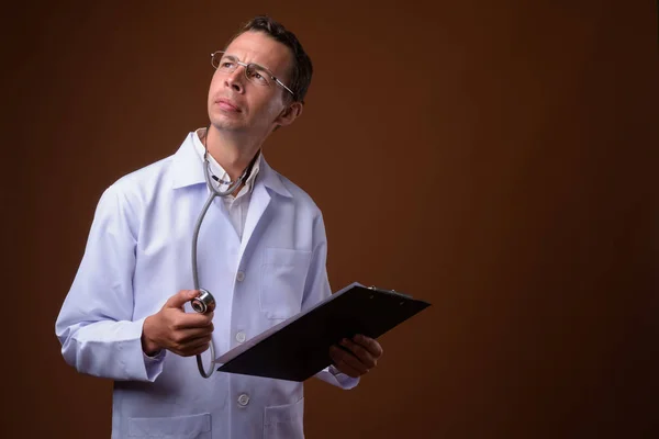 Studioaufnahme eines Arztes vor braunem Hintergrund — Stockfoto
