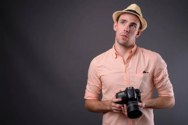 Joven hombre turista guapo sobre fondo gris —  Fotos de Stock