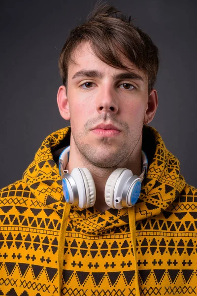 Estudio disparo de joven guapo hombre contra fondo gris —  Fotos de Stock