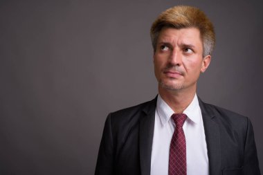 Gri arka plan sarı saçları ile işadamı