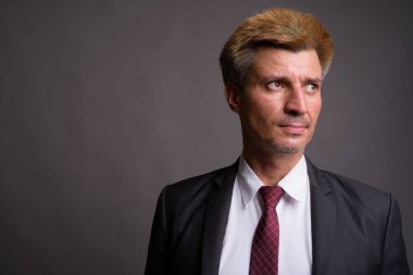 Gri arka plan sarı saçları ile işadamı