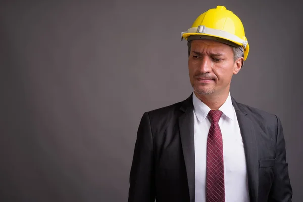 Retrato de hombre de negocios con hardhat sobre fondo gris —  Fotos de Stock