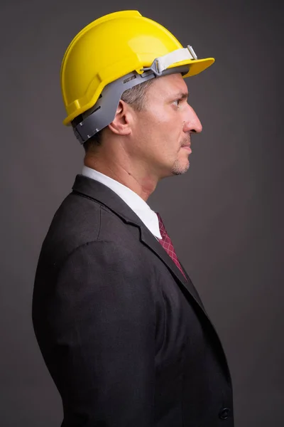 Retrato de hombre de negocios con hardhat sobre fondo gris — Foto de Stock