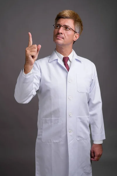 Adam doktor gri arka plan karşı sarışın saçlı — Stok fotoğraf