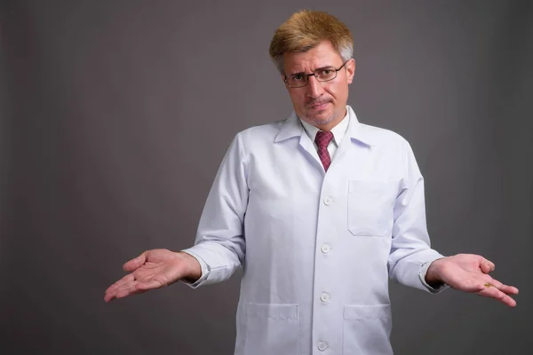 Man arts met blond haar tegen de grijze achtergrond — Stockfoto