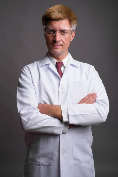 Άντρας γιατρός με ξανθά μαλλιά, φορώντας προστατευτικά γυαλιά κατά — Φωτογραφία Αρχείου