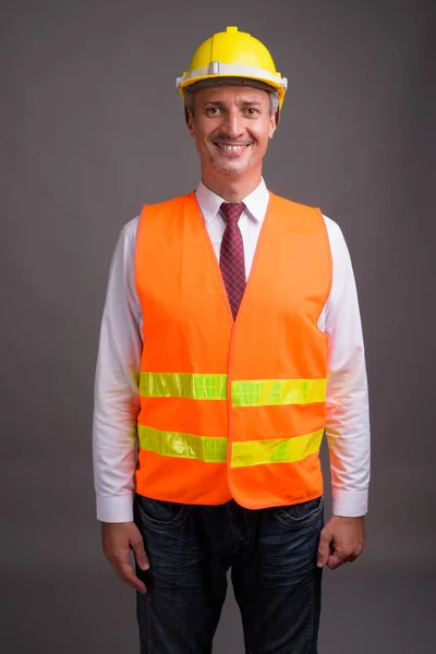 Retrato de homem trabalhador da construção contra fundo cinza — Fotografia de Stock