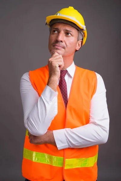 Retrato del trabajador de la construcción del hombre sobre fondo gris —  Fotos de Stock