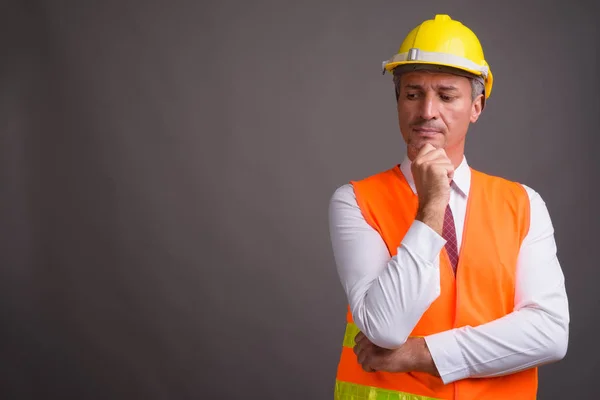 Retrato del trabajador de la construcción del hombre sobre fondo gris — Foto de Stock