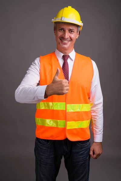 Porträt eines Bauarbeiters vor grauem Hintergrund — Stockfoto