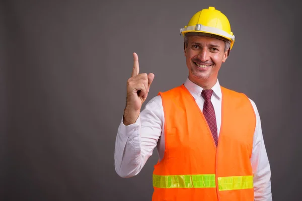 Portret van man bouwvakker tegen de grijze achtergrond — Stockfoto