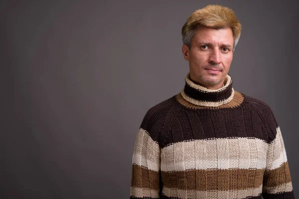 Mannen med blont hår polokrage tröja mot grå rygg — Stockfoto