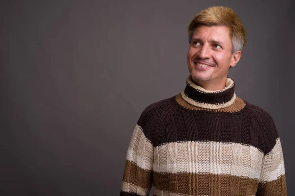 Mannen med blont hår polokrage tröja mot grå rygg — Stockfoto