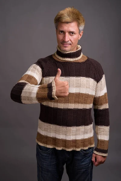 灰色の背中にタートルネックのセーターを着ている金髪の男の人 — ストック写真
