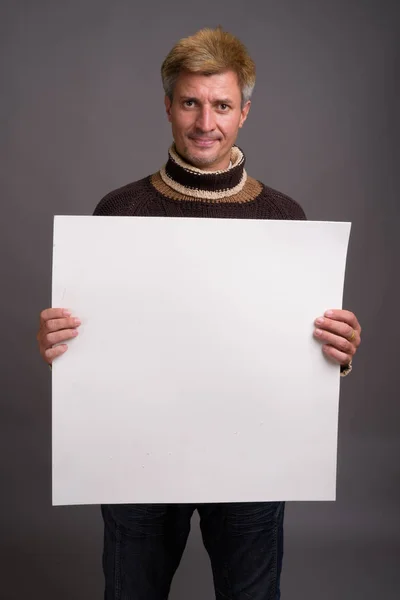 Mannen med blont hår polokrage tröja mot grå rygg — Stockfoto