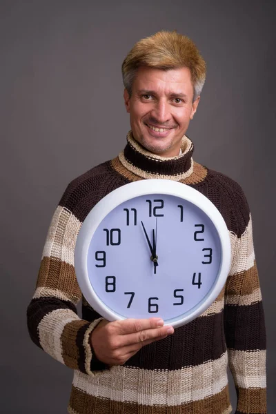 Man with blond hair wearing turtleneck sweater against gray back — Stock Photo, Image