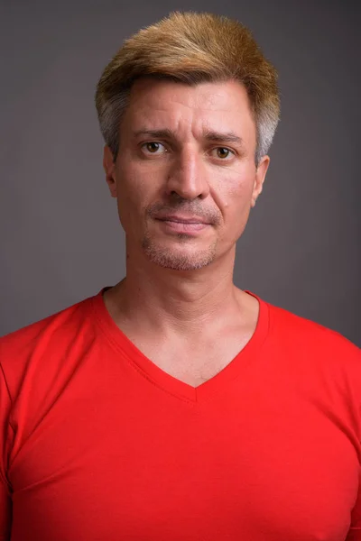 Man with blond hair wearing red shirt against gray background — Stock Photo, Image