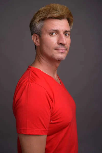 Man with blond hair wearing red shirt against gray background — Stock Photo, Image