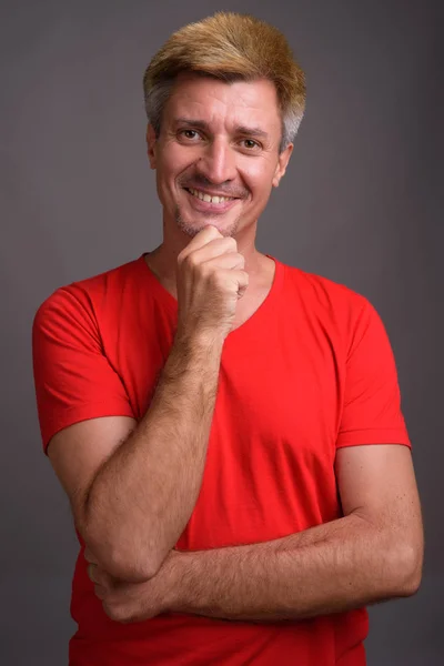Hombre de pelo rubio con camisa roja sobre fondo gris —  Fotos de Stock
