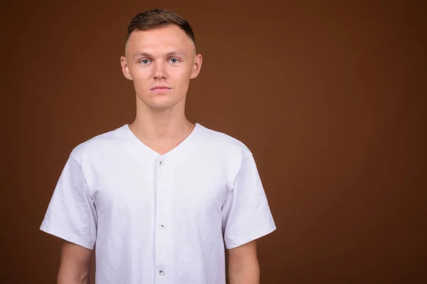 Estúdio Tiro Jovem Vestindo Camisa Branca Contra Fundo Marrom — Fotografia de Stock