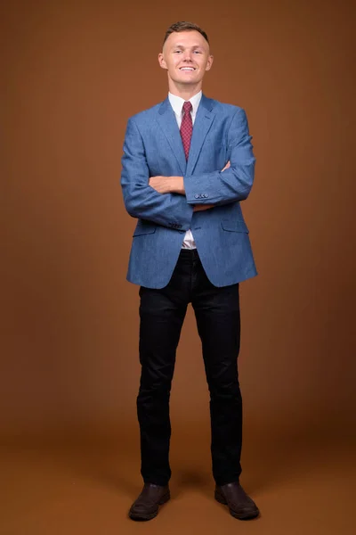 Молодий бізнесмен в костюмі на коричневому фоні — стокове фото