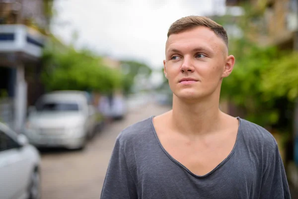 Hombre joven con camisa gris en las calles al aire libre — Foto de Stock