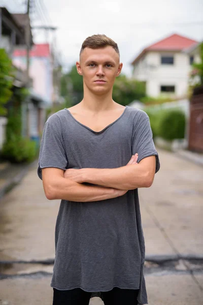Молодий чоловік у сірій сорочці на вулиці — стокове фото