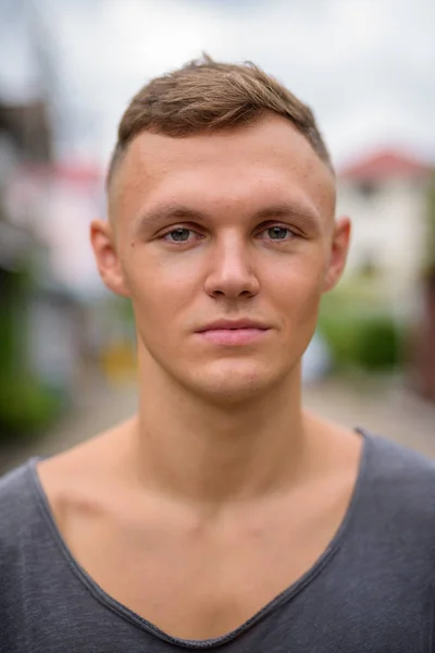 Young man wearing gray shirt in the streets outdoors — Stock Photo, Image