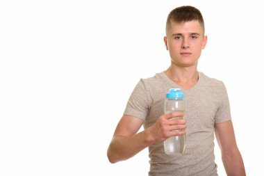 Beyaz delikanlı su şişesi tutarak ve kameraya bakıyor
