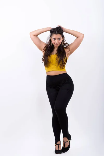 Full body shot of young beautiful Indian woman posing while hold