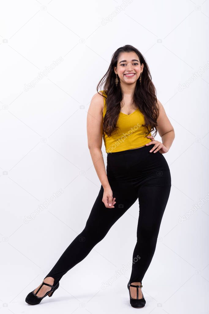 Full body shot of young happy Indian woman smiling while posing 