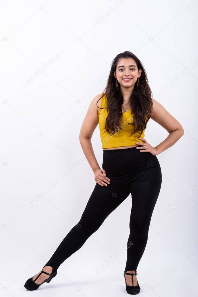 Full body shot of young happy Indian woman smiling while posing 