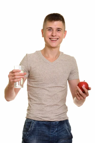 Jeune homme heureux caucasien souriant tout en tenant un verre d'eau a — Photo