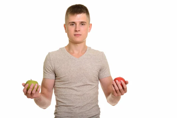 Joven hombre caucásico sosteniendo manzana roja y verde — Foto de Stock