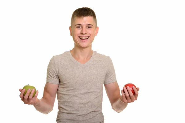 Joven feliz caucásico hombre sonriendo mientras sostiene rojo y verde ap — Foto de Stock