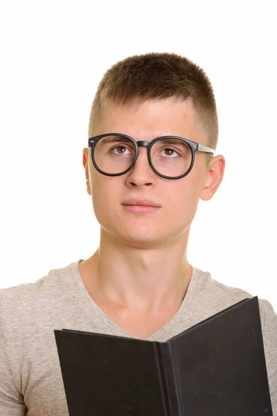 Jovem caucasiano homem segurando livro enquanto pensa — Fotografia de Stock