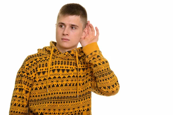 Young curious Caucasian man listening while cupping ear — Stock Photo, Image