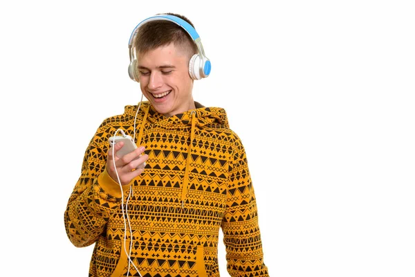 Junge glückliche kaukasische Mann lächelt, während mit Handy und l — Stockfoto