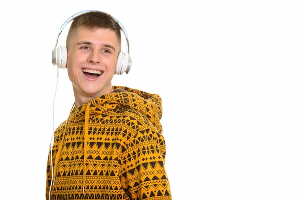 Nachdenklicher junger glücklicher Kaukasier, der lächelt, während er zuhört — Stockfoto