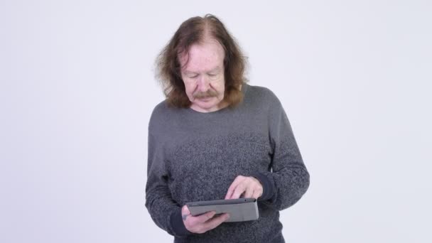 Hombre mayor feliz con bigote usando tableta digital y recibiendo buenas noticias — Vídeos de Stock
