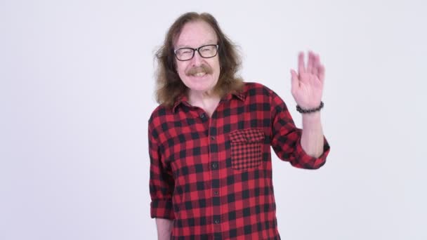 Mutlu üst düzey hipster adam el sallayarak gözlük ile — Stok video