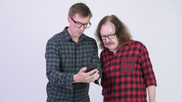 シニア ヒップスター男と若いヒップな男の携帯電話を使用して、一緒に悪いニュースを取得 — ストック動画