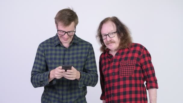 Senior hipster man steeds boos op jonge hipster man met telefoon — Stockvideo